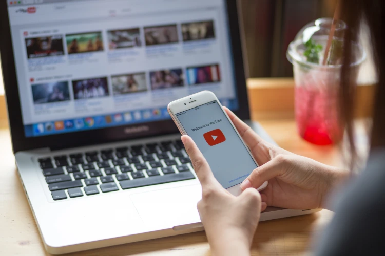 Woman holding iPhone with YouTube Woman holding iPhone with YouTube.