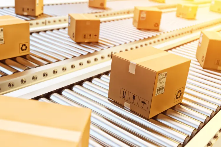 Cardboard boxes on conveyor belt in warehouse. Parcel shipment